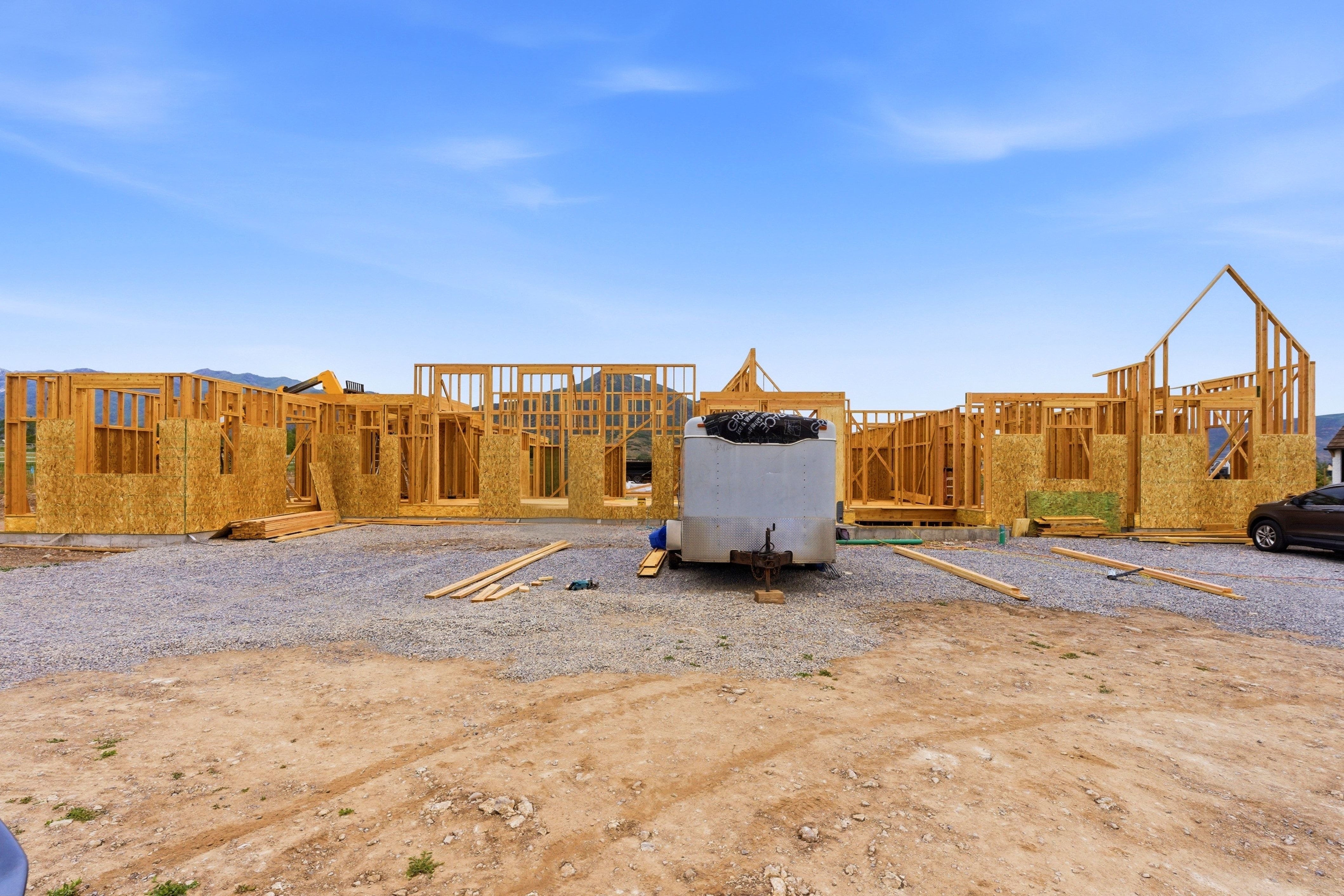 New construction framing showcasing an extensive footprint and an open-sky backdrop