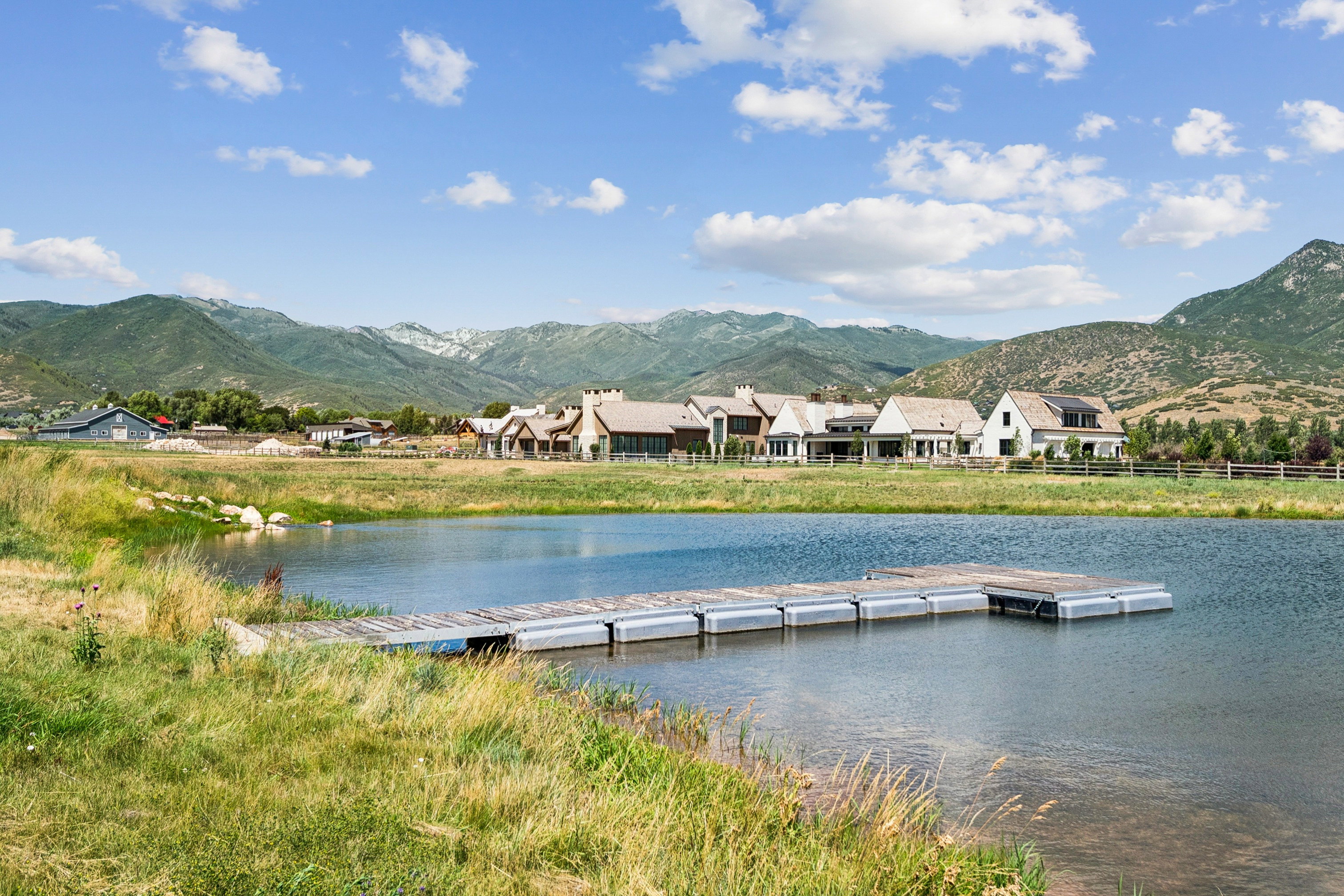 Lakeside property featuring a floating dock and natural grass shoreline