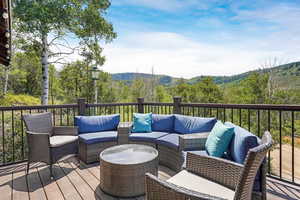 Wooden deck featuring a forest view and an outdoor living space
