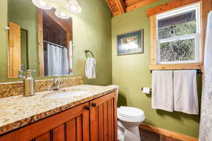Full bath with a textured wall, vanity, and a shower with shower curtain