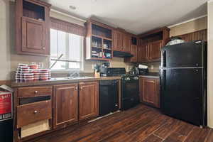 Kitchen featuring black appliances, dark wood-style flooring, under cabinet range hood, open shelves, and ornamental molding