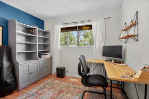 Office with light wood-style flooring and baseboards