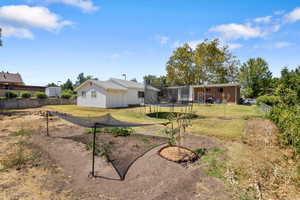 Back of property featuring a fenced backyard and a trampoline