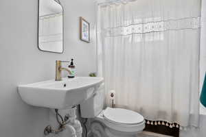 Bathroom with toilet and shower / bathtub combination with curtain