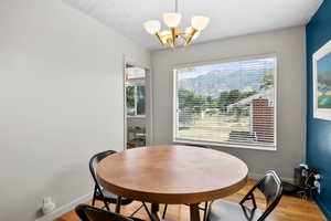 Dining space with light wood finished floors and a chandelier