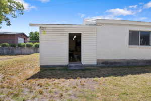 Rear view of property featuring an outdoor structure and concrete block siding