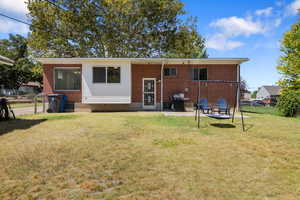 Rear view of house featuring brick siding, a patio area, and a chimney