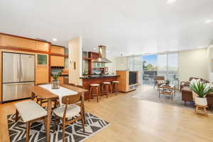 Dining space with light wood finished floors, expansive windows, and recessed lighting