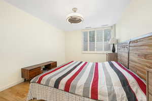 Bedroom with wood finished floors and baseboards