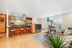 Living area with light wood-style flooring and expansive windows
