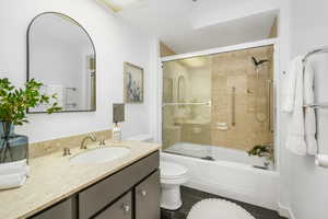 Full bathroom featuring vanity, tile patterned floors, and bath / shower combo with glass door