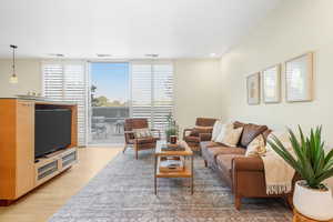Living room featuring light wood-style floors, expansive windows, and recessed lighting