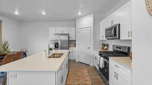 Kitchen featuring appliances with stainless steel finishes, dark wood finished floors, white cabinets, light countertops, and recessed lighting