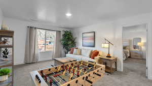 Living area with light carpet and a textured ceiling