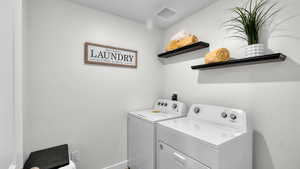 Laundry area with washer and dryer and baseboards