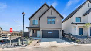 View of front facade featuring stucco siding, concrete driveway, an attached garage, and a mountain view