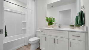 Bathroom with vanity, shower / tub combo, and wood finished floors