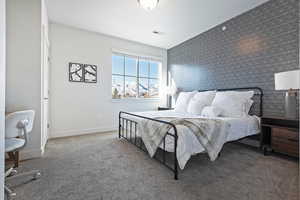 Carpeted bedroom with an accent wall and wallpapered walls