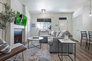 Living room with wood finished floors, a fireplace, and a textured ceiling