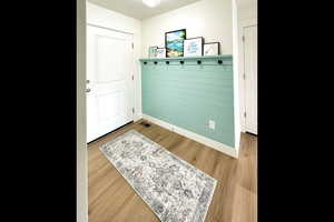 Mudroom featuring wood finished floors and baseboards