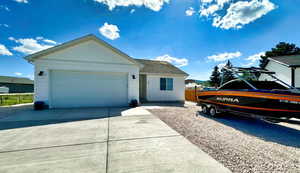 Ranch-style home featuring a garage, driveway, and a shingled roof