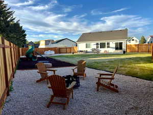 Fenced backyard featuring a patio and a playground