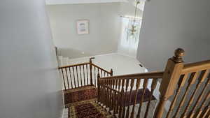 Stairway featuring carpet and a chandelier