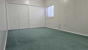 Basement bedroom with multiple closets and carpet floors