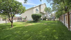 Fenced backyard featuring a deck