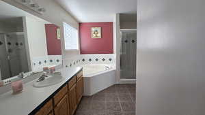 Bathroom with vanity, a stall shower, a bath, and tile patterned floors