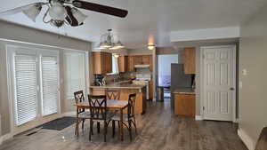 Dining room featuring wood finished floors, a ceiling fan, and a chandelier