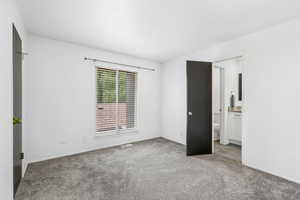 Unfurnished bedroom with carpet floors and connected bathroom