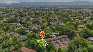 Aerial view of residential area with property parcel outlined and mountains