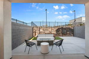 Fenced backyard featuring a patio area and an outdoor living space with a fire pit