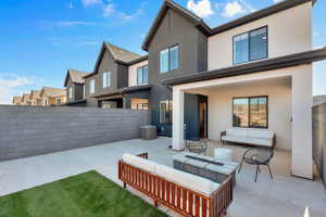 Back of property featuring an outdoor living space, stucco siding, a patio area, and a residential view