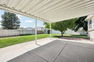 Fenced backyard with a storage unit and a patio area