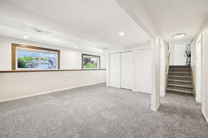 Basement with carpet flooring, stairway, and recessed lighting