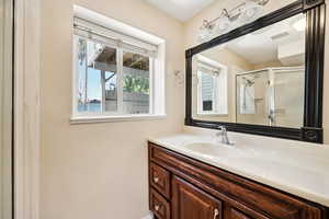 Full bath featuring a shower stall and vanity