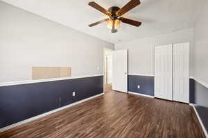 Unfurnished bedroom with wood finished floors, a textured ceiling, a closet, and ceiling fan