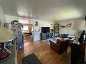 Living area featuring wood finished floors and a textured ceiling