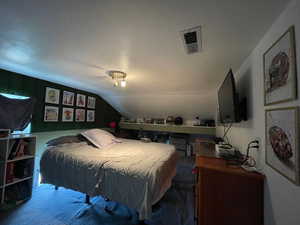 Carpeted bedroom featuring lofted ceiling