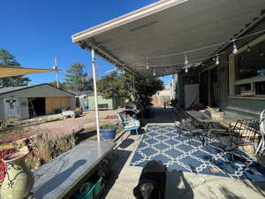 View of patio featuring outdoor dining space and an outbuilding
