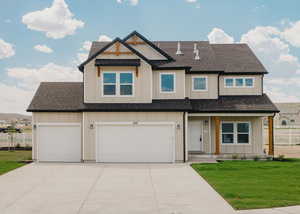 View of front facade with roof with shingles, concrete driveway, an attached garage, and board and batten siding