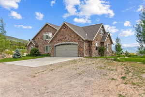 Craftsman inspired home with concrete driveway, stone siding, a garage, and a front yard
