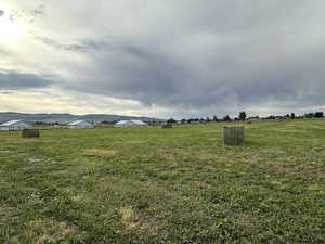 View of green lawn with a mountain view and a view of countryside