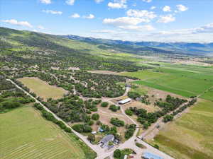 Aerial view of sparsely populated area with a mountain backdrop and extensive farmland