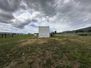 View of yard featuring a view of rural / pastoral area, an outdoor structure, and a mountain view