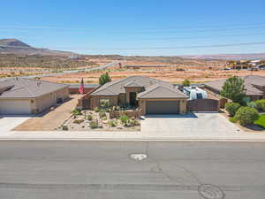 View of front of house with driveway, a gate, a garage, stucco siding, and a mountain view