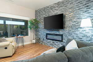 Living area featuring wood finished floors and a large fireplace