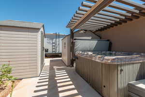 View of patio / terrace with a hot tub and a pergola